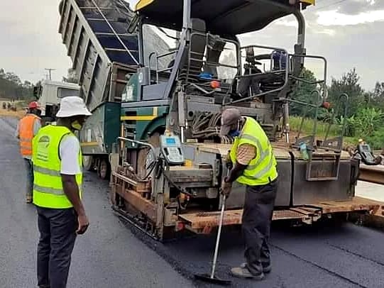 Paving train operation on county highway development project.